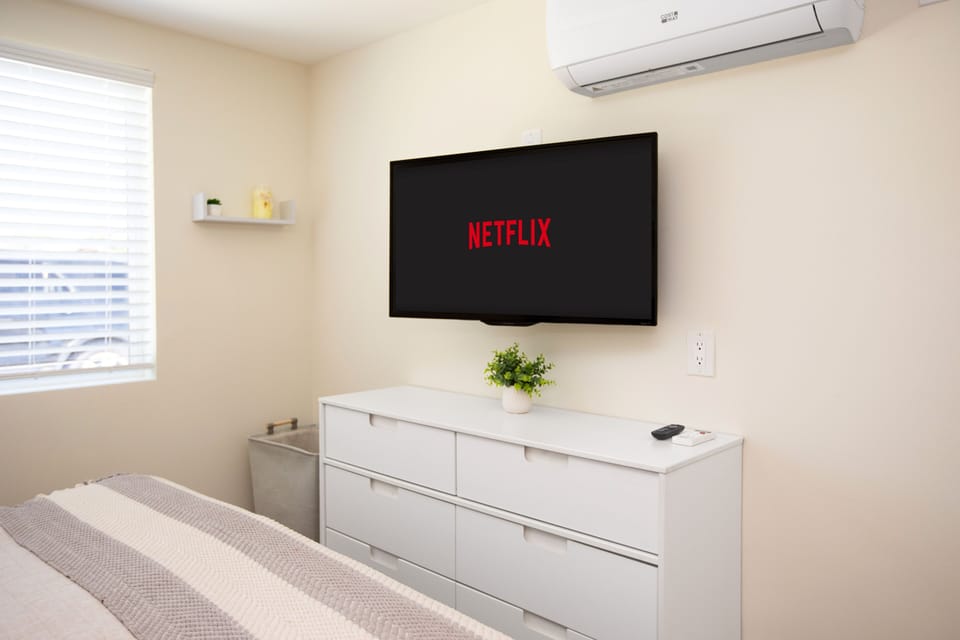 Smart TV and dresser in cozy bedroom