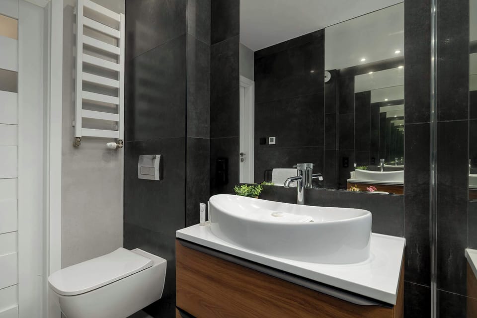 The bathroom's contemporary design includes fresh towels and a hairdryer.