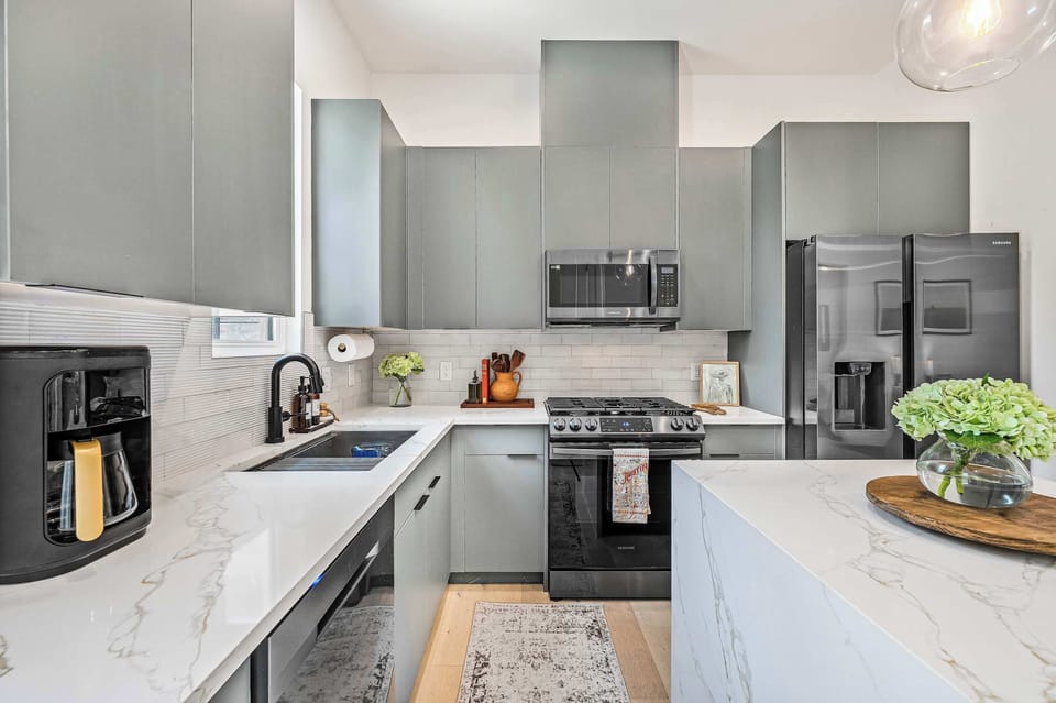 Kitchen full view with fridge, oven, sink, island, dishwasher and coffee maker
