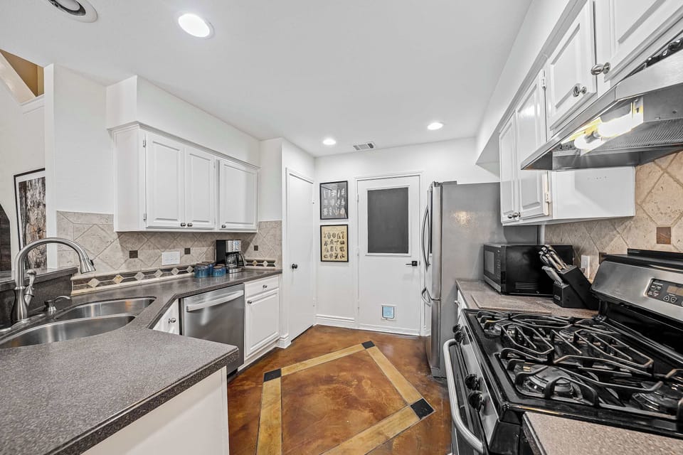 Full kitchen view of stove fridge door to garage pantry dishwasher and sink