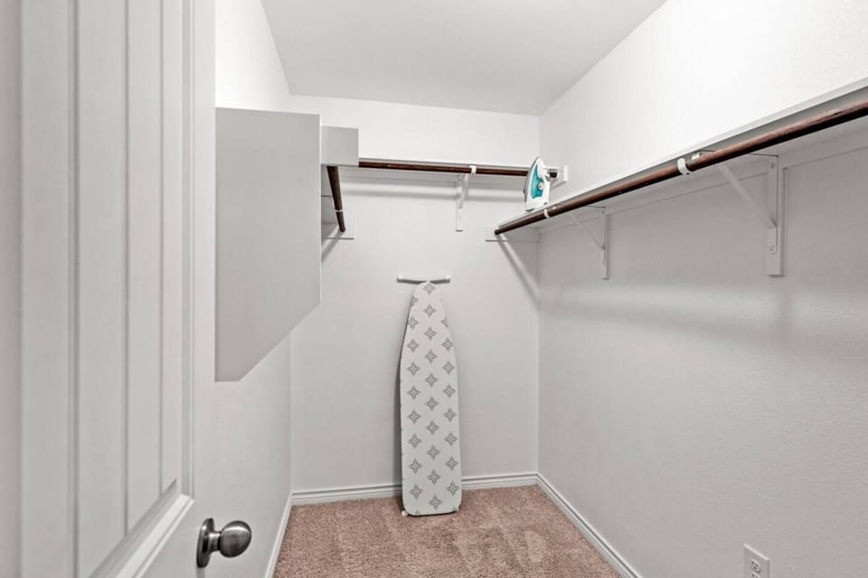 Spacious walk-in closet with ample storage space, perfect for long-term guests. Equipped with an iron and ironing board for your convenience, making it easy to keep your clothes fresh and organized during your stay.