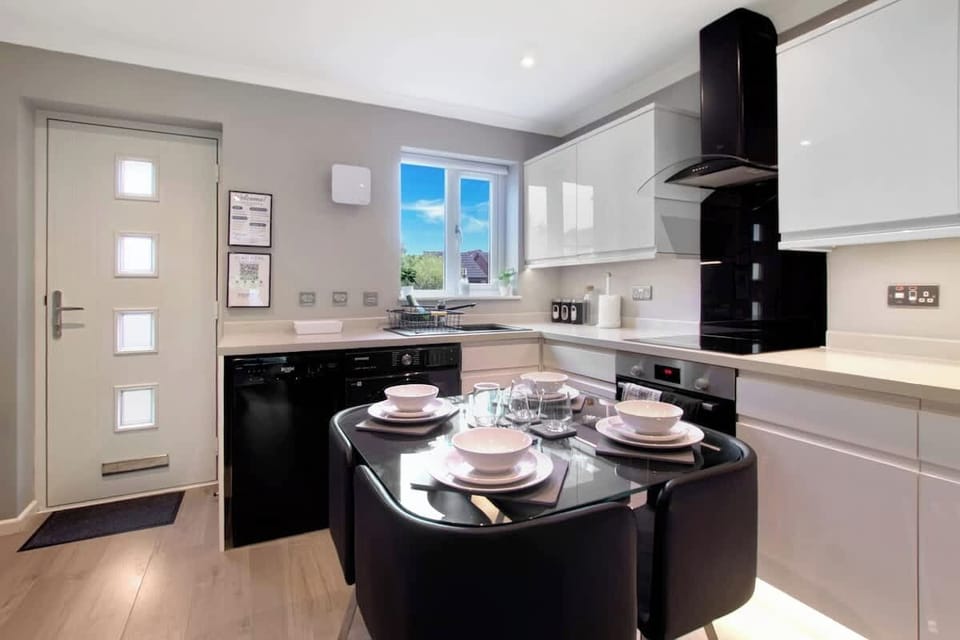 Modern Kitchen & Dining Area: A stylish, fully equipped kitchen featuring modern appliances, an electric hob and oven, microwave, kettle, toaster, and a spacious fridge-freezer. The dining table provides a comfortable space to enjoy meals together.