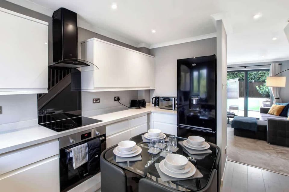 Modern Kitchen & Dining Area: A stylish, fully equipped kitchen featuring modern appliances, an electric hob and oven, microwave, kettle, toaster, and a spacious fridge-freezer. The dining table provides a comfortable space to enjoy meals together.
