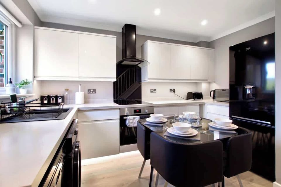 Modern Kitchen & Dining Area: A stylish, fully equipped kitchen featuring modern appliances, an electric hob and oven, microwave, kettle, toaster, and a spacious fridge-freezer. The dining table provides a comfortable space to enjoy meals together.