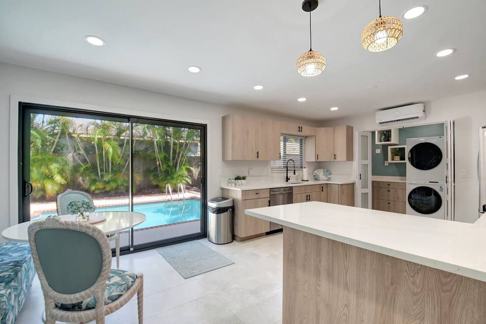 Kitchen view showcasing sleek cabinetry and direct access to the sun-soaked pool patio.
