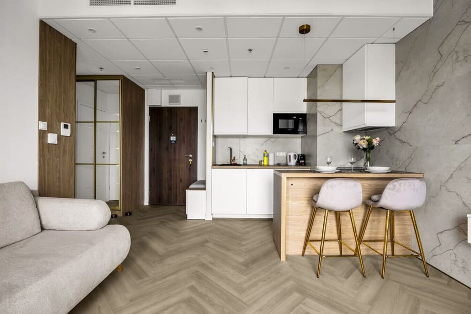 Living Room – Wall-Mounted Flat TV, Compact Vanity Desk, and Access to a Private Balcony | Book Now with RENTUJEMY.COM