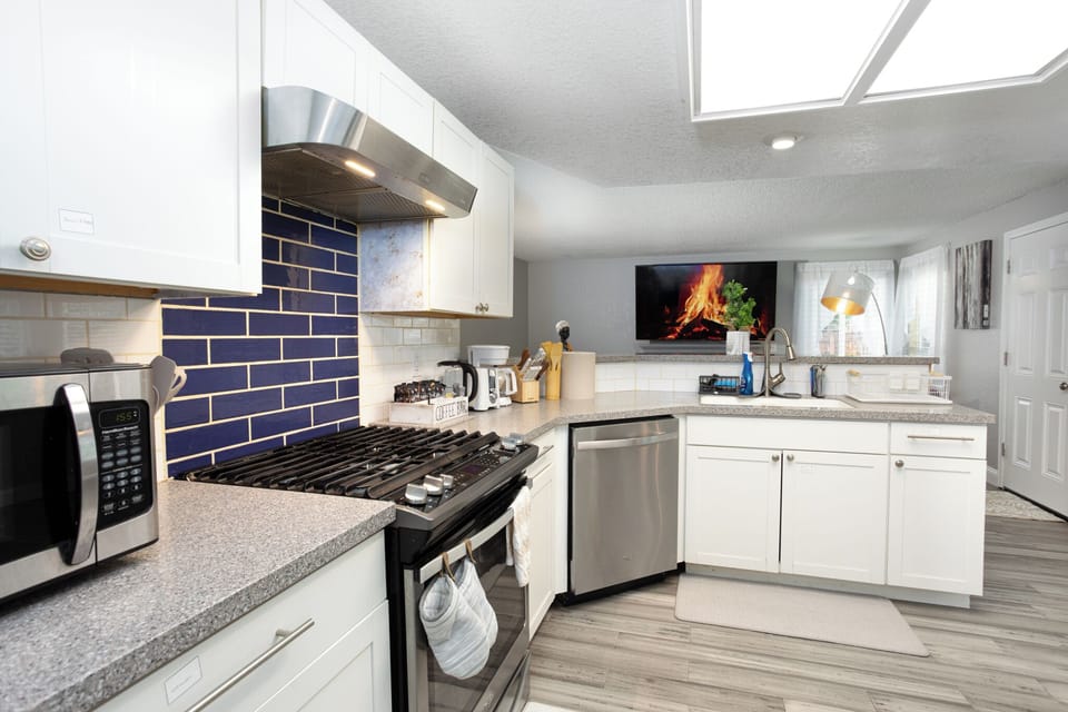 Kitchen with refrigerator, cooking stove, oven, microwave, cooking utensils