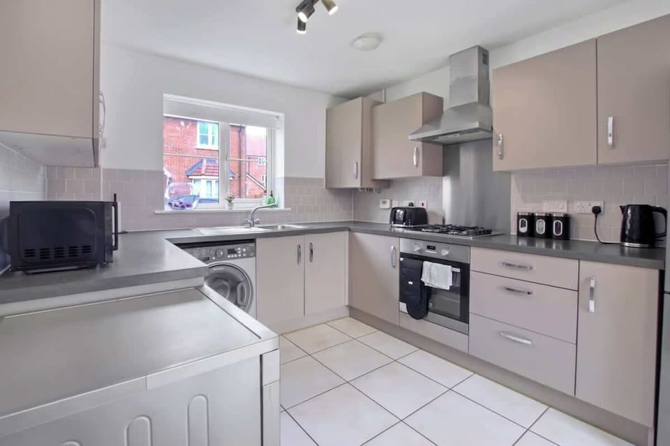 Fully Equipped Kitchen: Modern kitchen with oven, hob, microwave, dishwasher, washing machine, kettle and toaster.
