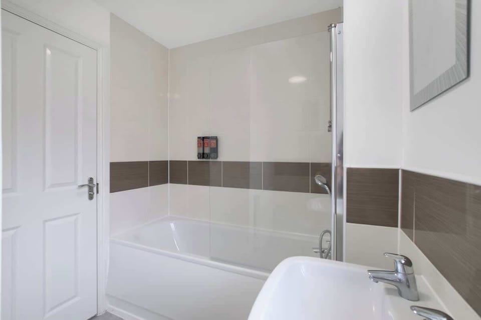 Main Bathroom: Spacious bathroom with full-size bath and overhead shower.
