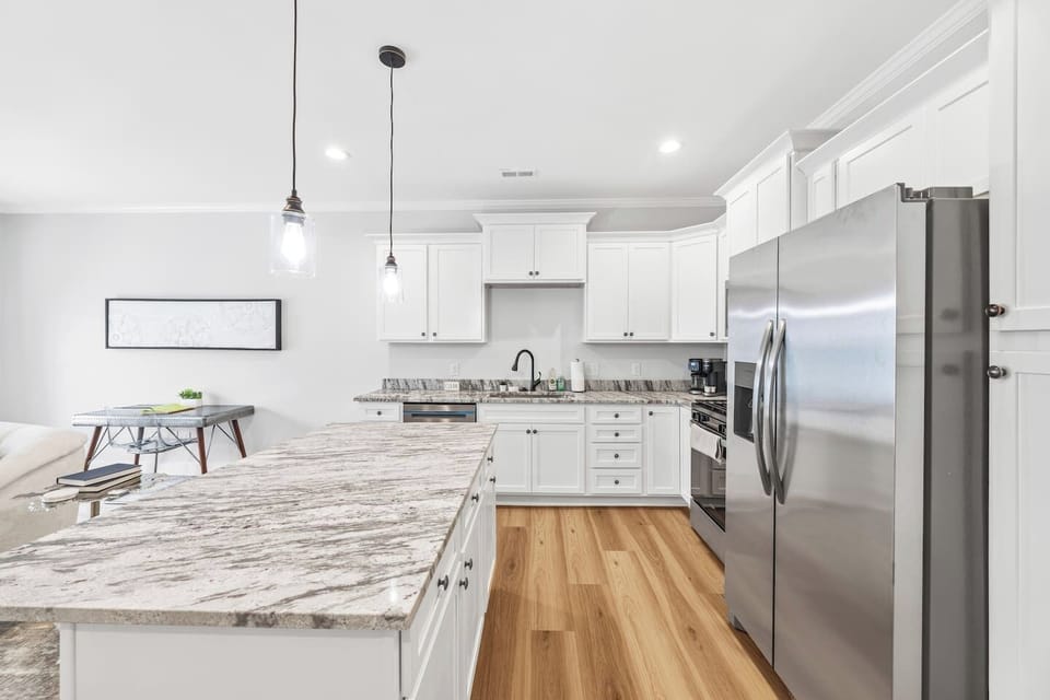 Cook in style with stainless steel appliances, a generous marble island, and crisp white cabinetry — where form meets function.