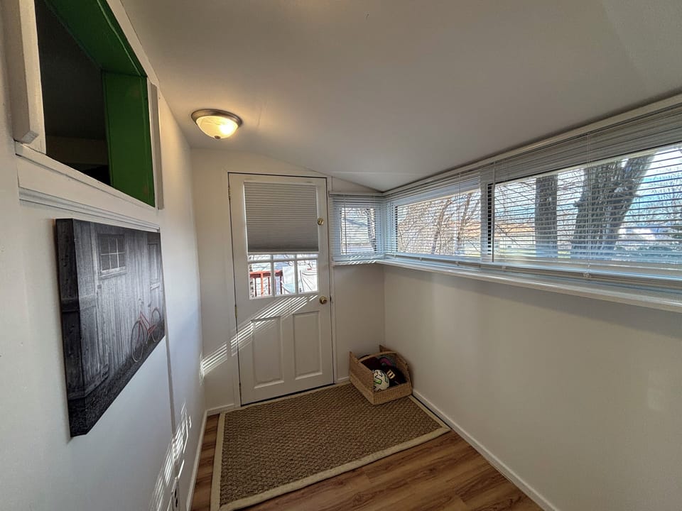 Sunroom at back of house with patio access & extra space for bags and shoes