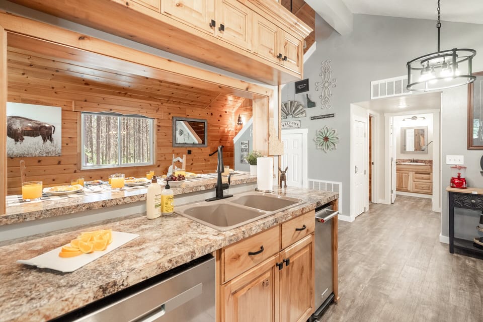 Bright, rustic, and designed for gathering—this fully stocked kitchen and breakfast bar is where mornings start slow and evenings linger. Natural wood tones, generous counter space, and cozy cabin charm set the scene at Roaming Buffalo.
