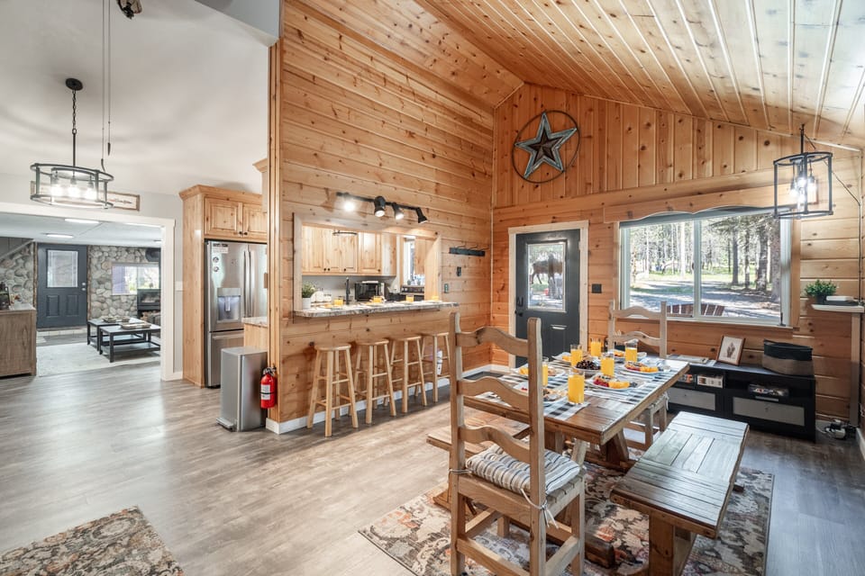 Enjoy meals together in this cozy dining area featuring bar seating, rustic tongue-and-groove wood, and plenty of room to gather and unwind.