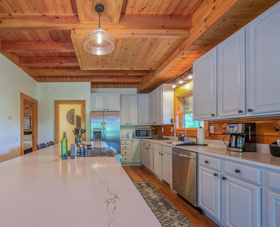 Kitchen with large island, seating for 4, dishwasher, and drip-style coffee maker