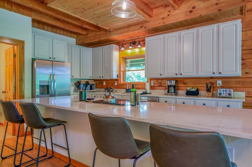 Kitchen with large island, seating for 4, dishwasher, and drip-style coffee maker