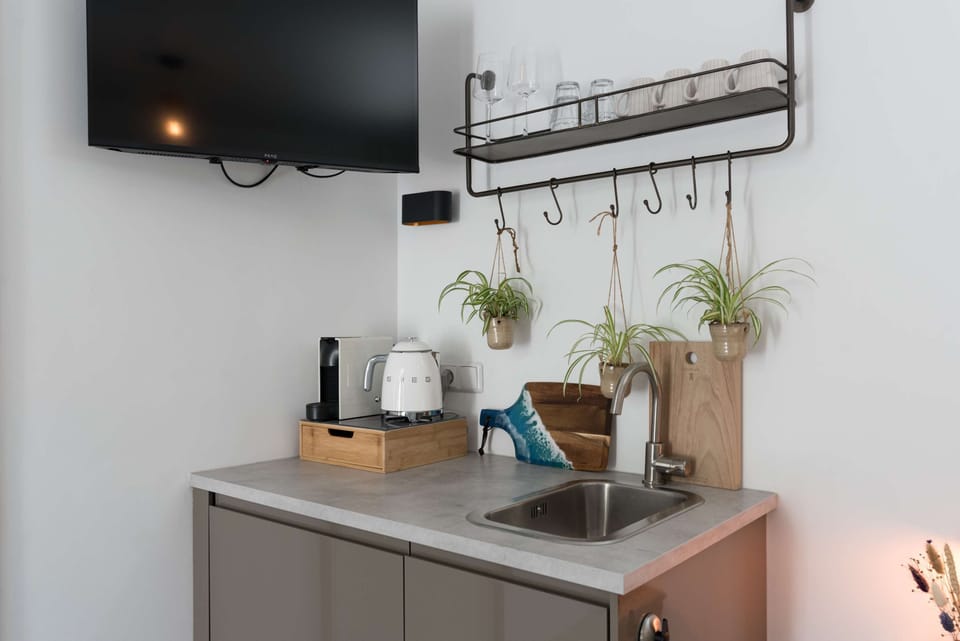 Equipped with a Nespresso machine, kettle, mugs, and a smart TV, all within arm’s reach.