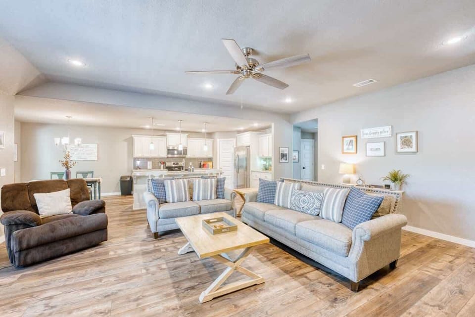 🚺 Open-concept living room flows to kitchen & dining; enjoy plush seating, Smart TV & abundant light.