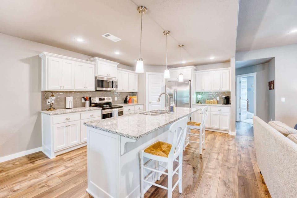 👩‍🍳 Chef’s kitchen with granite counters, stainless appliances & a large island opens to dining & living areas.