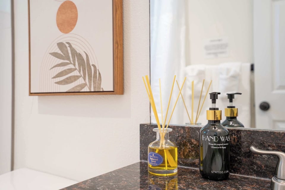 Bathroom Details--- Luxury meets function with marble countertops, gold-accented soap dispensers, and a fragrant reed diffuser.