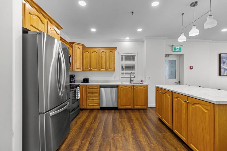 Fully equipped kitchen with elegant wooden cabinets, stainless steel appliances, and a spacious island perfect for cooking and entertaining.