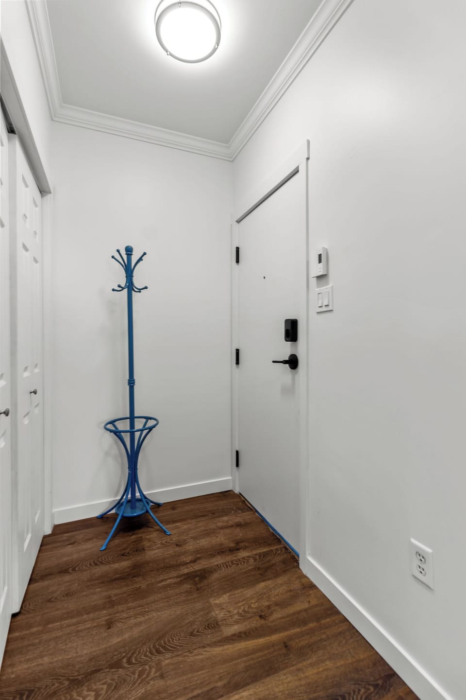 Bright and modern entryway featuring a sleek blue coat rack and secure smart lock system.