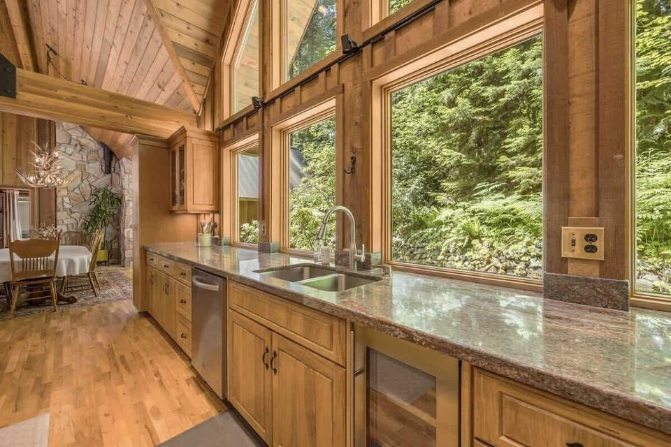 
Cook with a view! This stunning kitchen overlooks lush greenery, bringing nature indoors for a unique culinary experience.