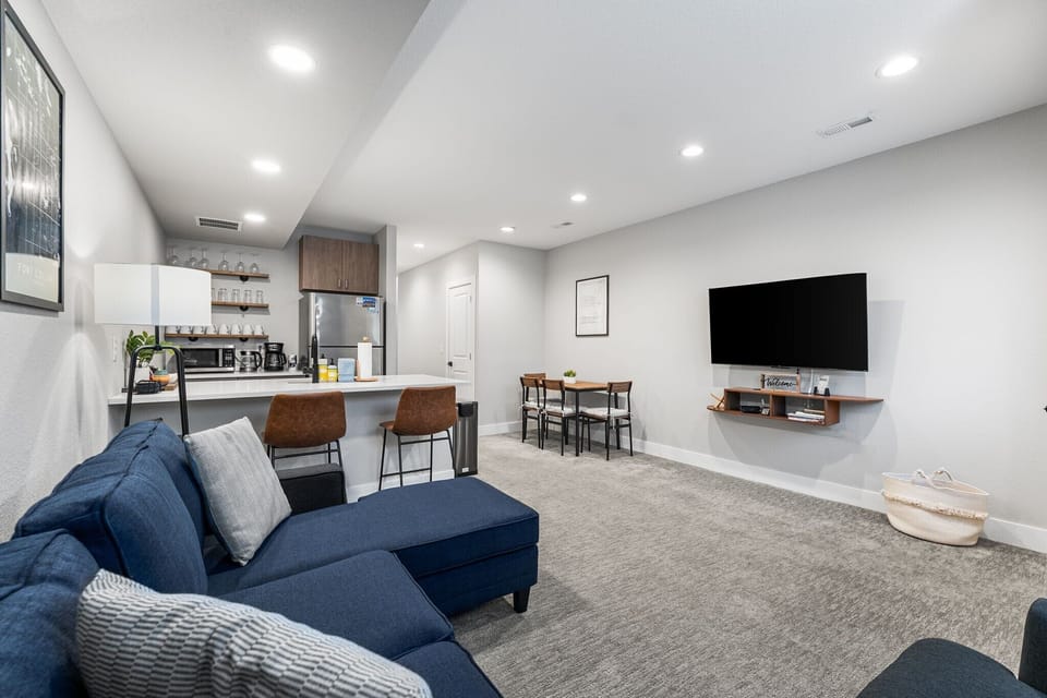 Open-concept living area with a comfy sectional, breakfast bar, and large TV for relaxing nights in.