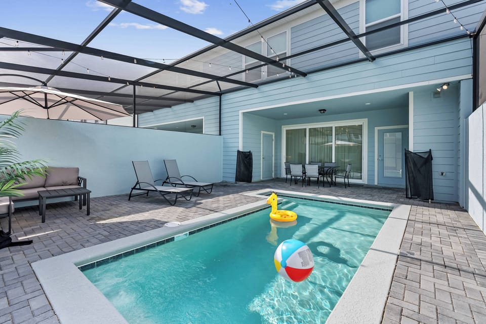 Step outside to your private pool area, nestled in a sleek screen enclosure for comfort and privacy. Relax on stylish seating while enjoying vibrant beach balls and refreshing water, making it the perfect spot to unwind.