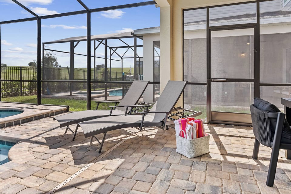 Step outside to enjoy a sun-kissed patio with inviting lounge chairs. The brick pavers lead you to a sparkling pool, complete with a protective screen so you can savor the fresh air in peace.