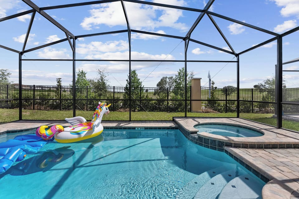 Welcome to your private oasis, complete with a sparkling pool enclosed for stunning views of the lush outdoors. Enjoy a refreshing dip in the inviting water, while a colorful float adds a playful vibe to your retreat.