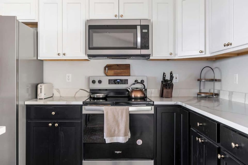 Full kitchen with stainless range, microwave, and quartz counters