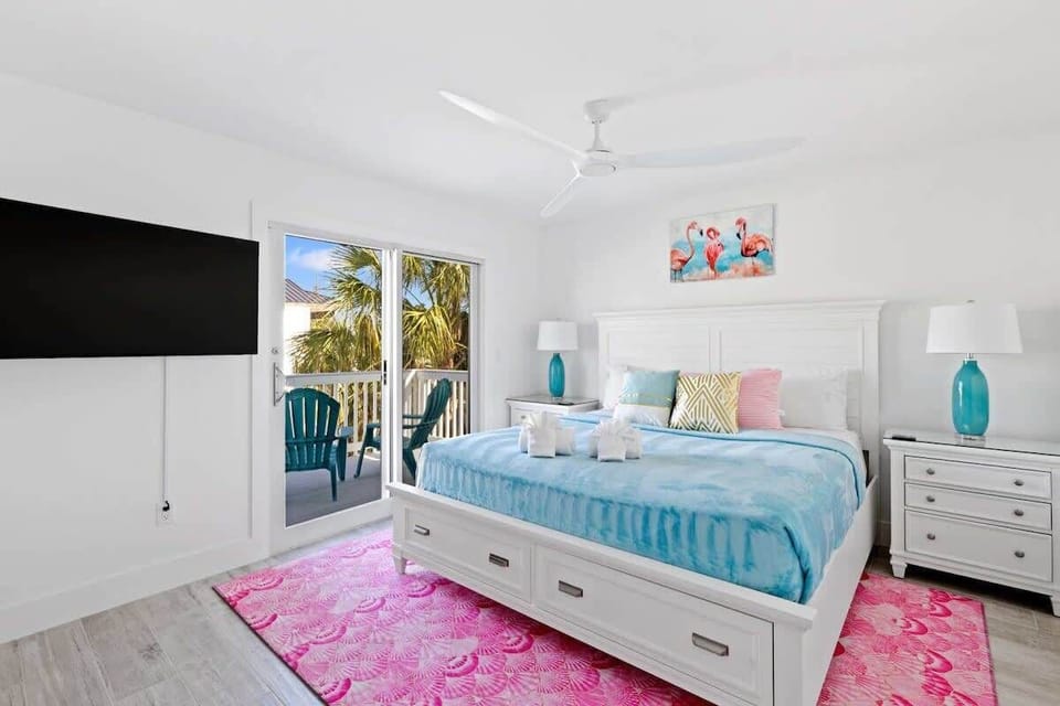 Primary Bedroom: Experience vibrant decor, pool views, and a breezy balcony for ultimate relaxation! Plus a smart TV and ensuite full bath