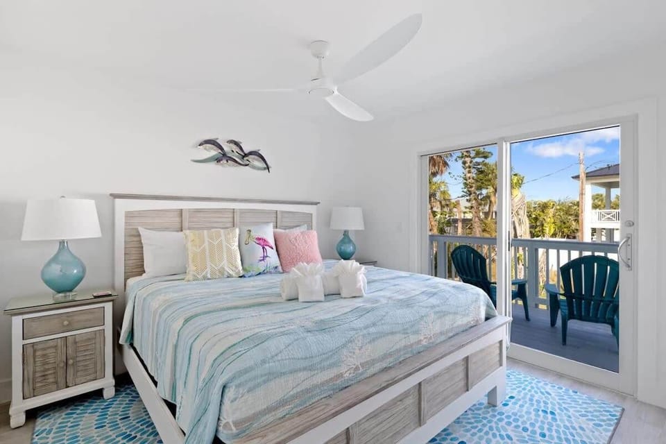 Comfortable King Bed with balcony and seating overlooking the backyard and pool
