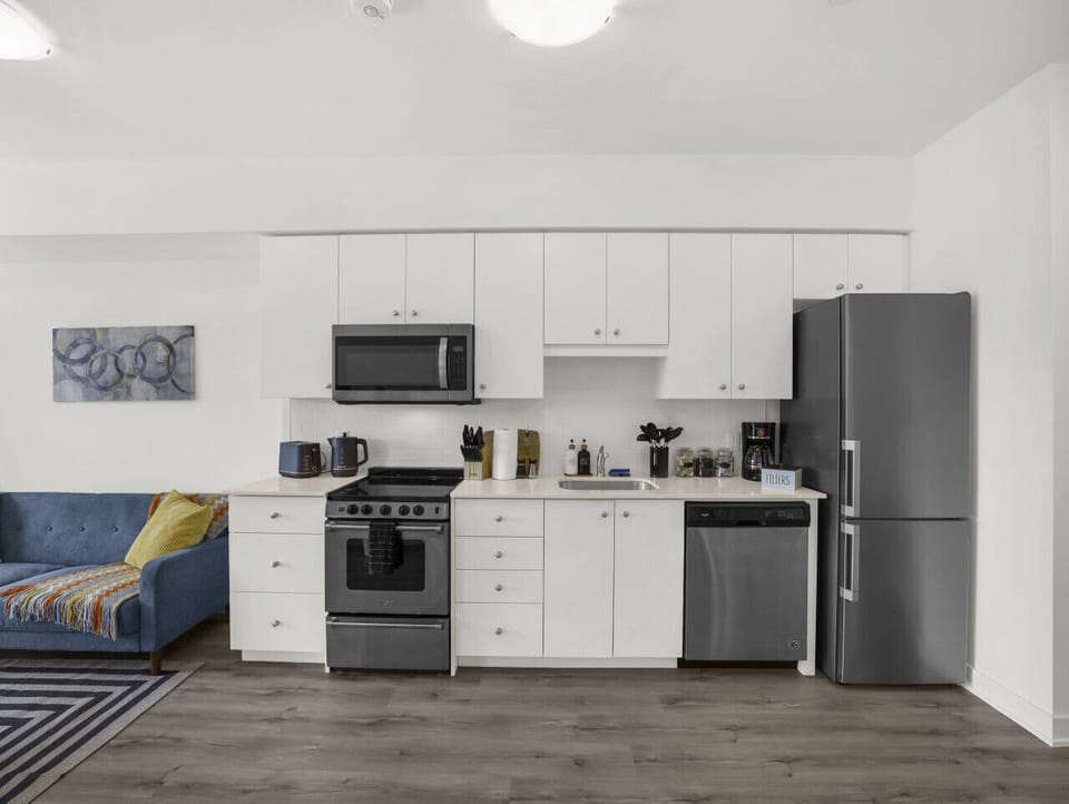Cook and dine with ease! This fully equipped, modern kitchen features stainless steel appliances, white cabinetry, and everything you need to prepare meals during your stay.