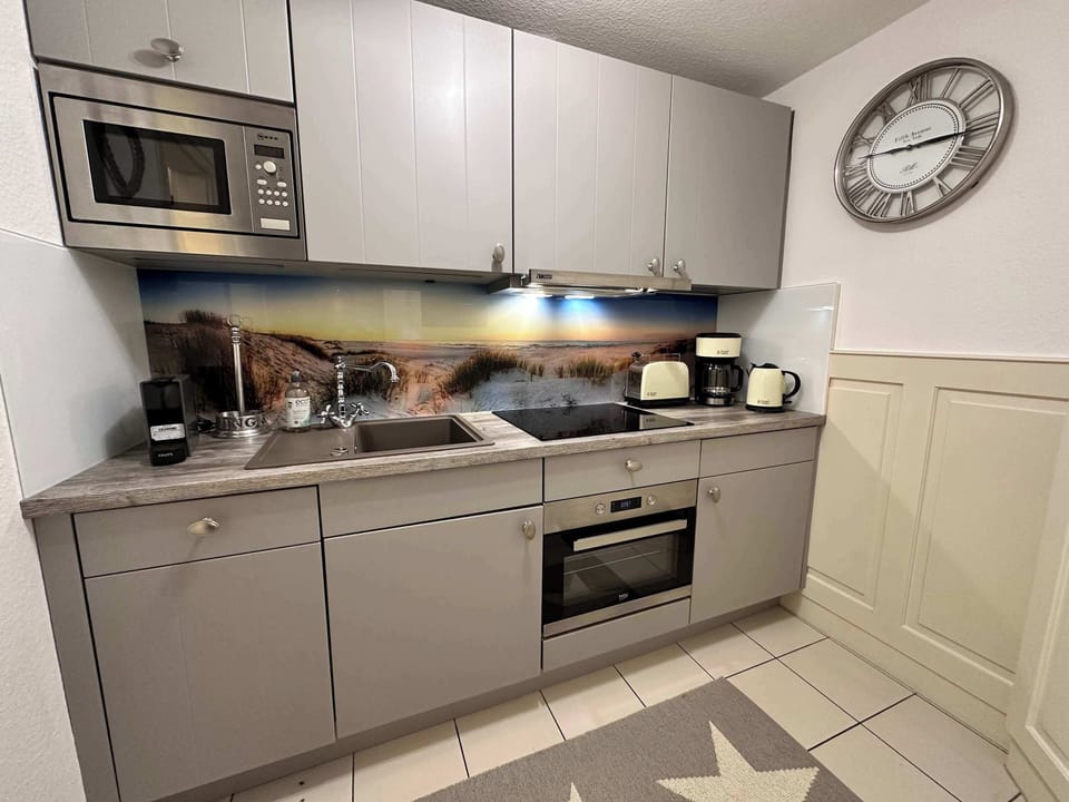 Separate Küche mit Mikrowelle, Nespressomaschine Geschirrspüler, Kaffeemaschine, Toaster, Dunstabzug, Ceranfeld, Wasserkocher und jeder Menge Kochzubehör.