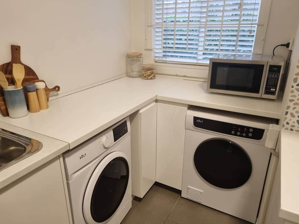 European style laundry located in the corner of the kitchen, Full washing machine and dryer