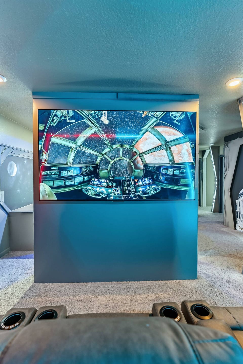 Experience your own private cinema in this stunning entertainment room, where a large screen and sleek blue accents create the perfect atmosphere. Plush seating beckons you to relax and enjoy your favorite films like never before.