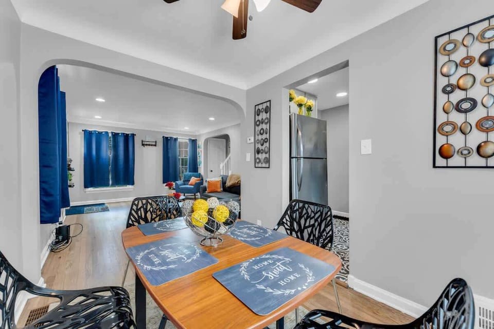 - Dining area with modern table set for four guests   - Bright open view connects to living room and kitchen   - Contemporary decor with wall art and bold accents  