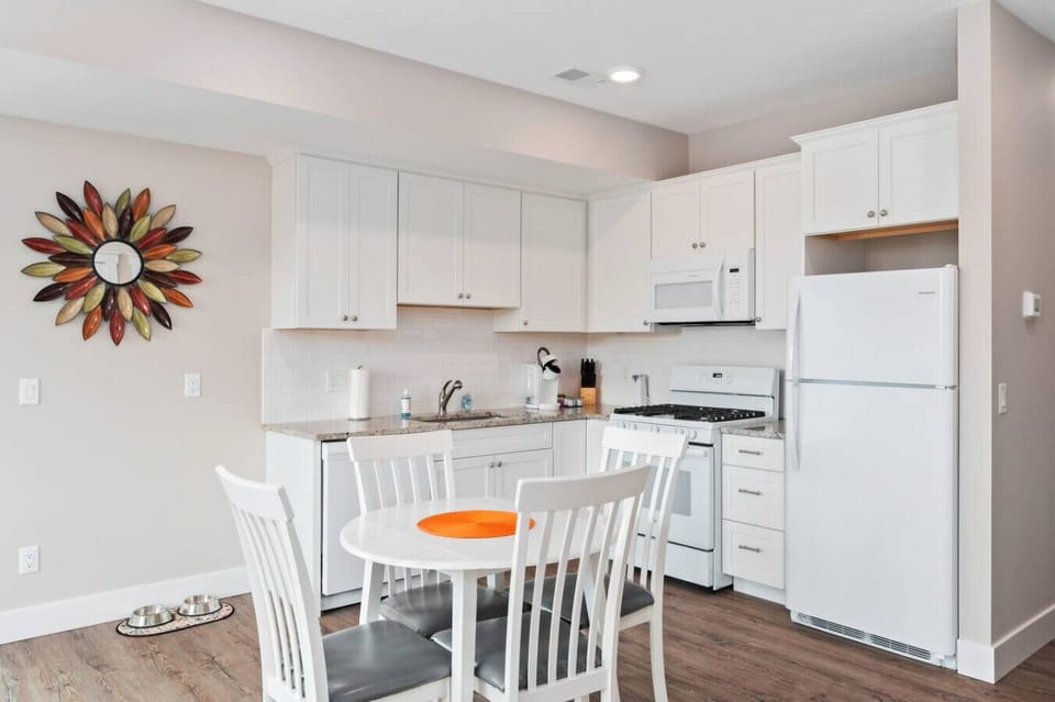 Clean and inviting kitchen with bright white cabinetry, cozy dining nook, and a pop of warm accent decor 🍽️✨