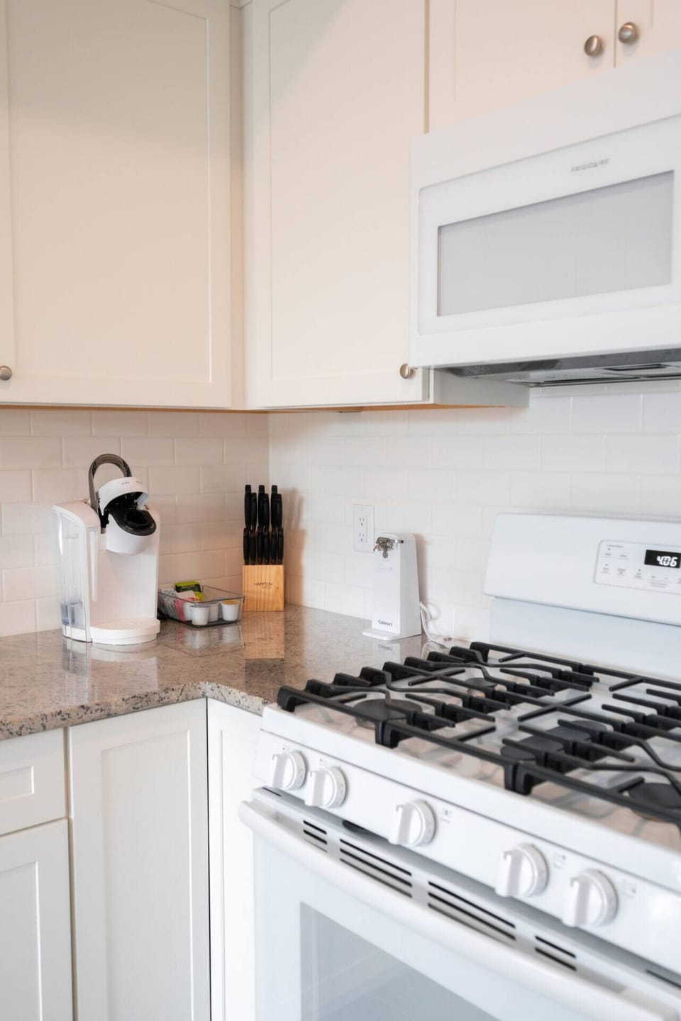 A bright, modern kitchen corner with sleek white cabinets, a cozy coffee station, and a clean gas stove ready for cooking ☕✨