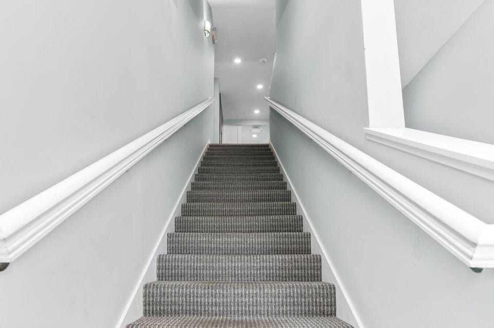 Follow the bright, carpeted entryway up to your private retreat. 🪜✨
