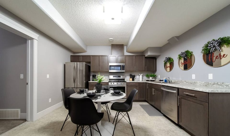 Stylish open kitchen with stainless steel appliances and dining area, perfect for family meals or entertaining during your stay.