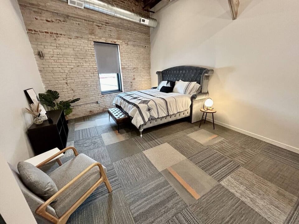 Spacious main bedroom with comfy pillowtop king bed, ceiling fan, and an ensuite bathroom.