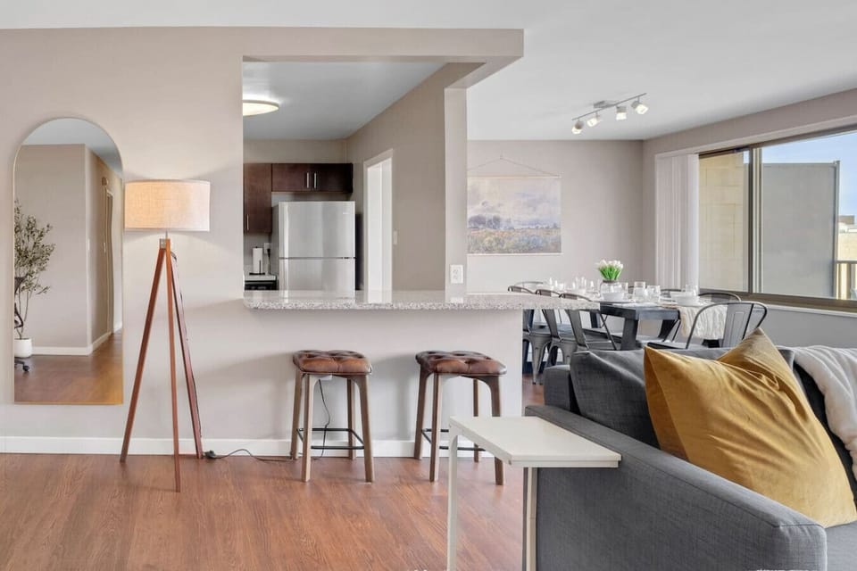 The open kitchen pass-through keeps the cook connected to the group — hand off plates, pour drinks, and never miss a beat of the conversation.