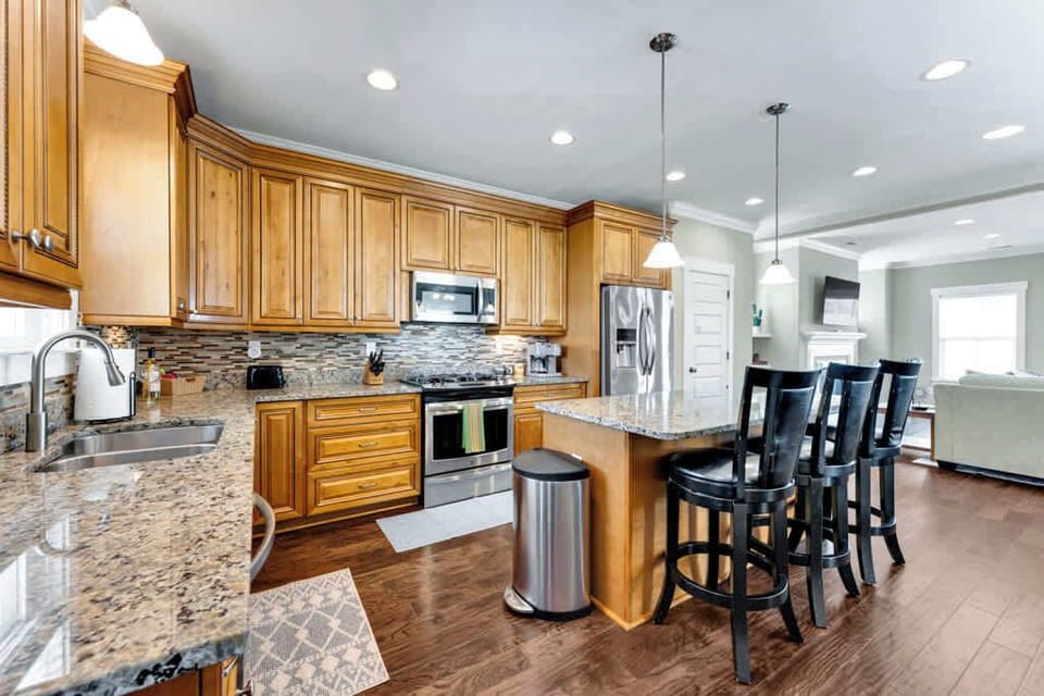Full kitchen view with living room next to it.