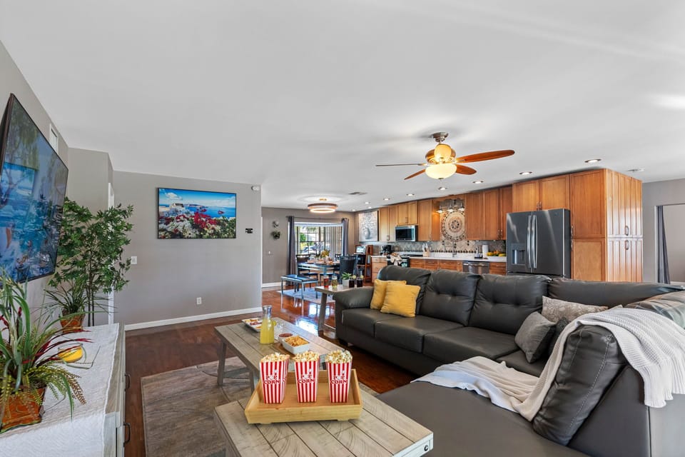 With a large TV setup, abundant seating, and easy access to the kitchen for snacks, this living room is the ultimate entertainment hub.