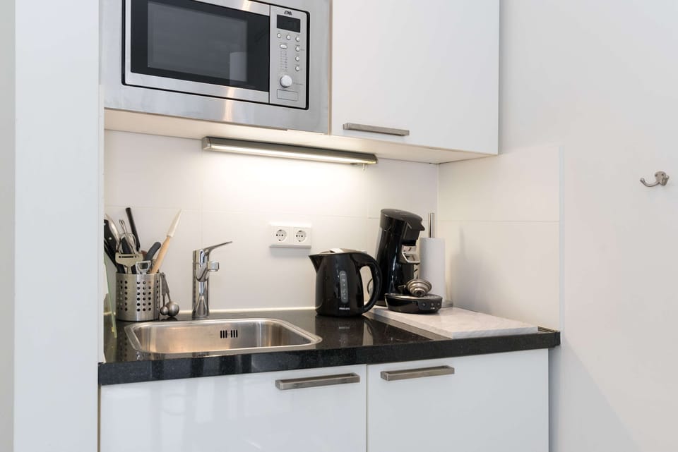 Compact yet complete: fridge, combination microwave, coffee maker, and dinnerware included.