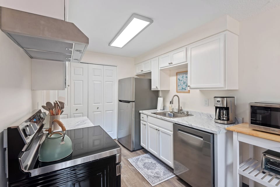 Fully stocked kitchen with coffee station, stainless appliances, and adjacent dining area - ideal for family meals.