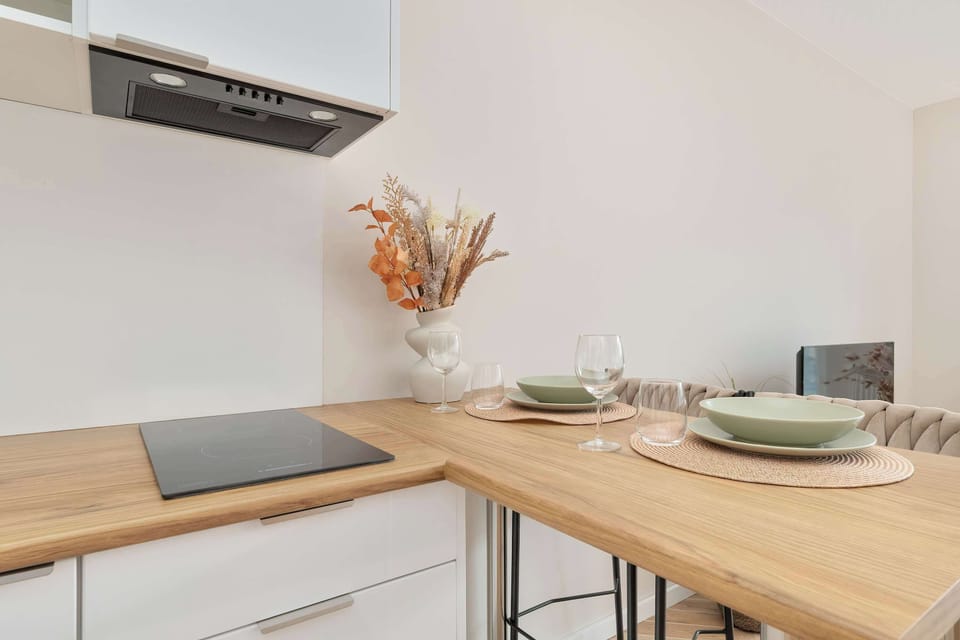 Kitchen corner with wooden countertop, light decor, and overhead extractor hood.