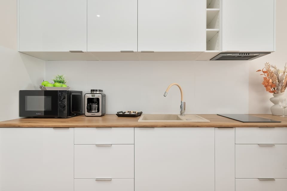 Compact open-plan kitchen with modern cabinets, a small dining table, and neutral décor.